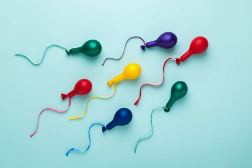 Colorful balloons in spermatozoid shape on a blue